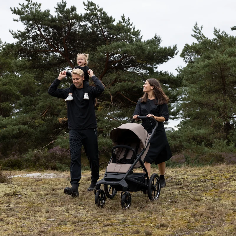 Familie spaziert durch den Wald mit dem Thule Urban Glide 4-Rad-Kinderwagen.