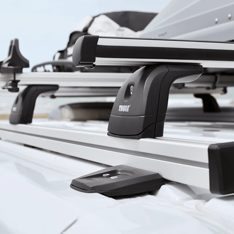 A close-up of a van with a Thule ProBar Flex van rack and a roof box attached.