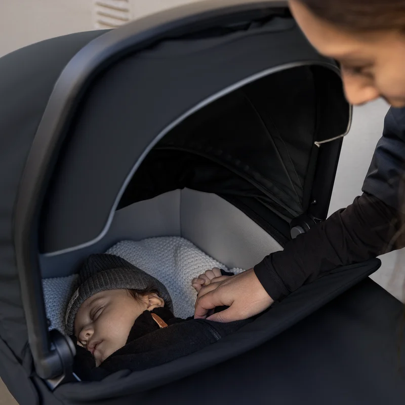 Elternteil legt ein Baby in die Thule Urban Glide 3 Babywanne.