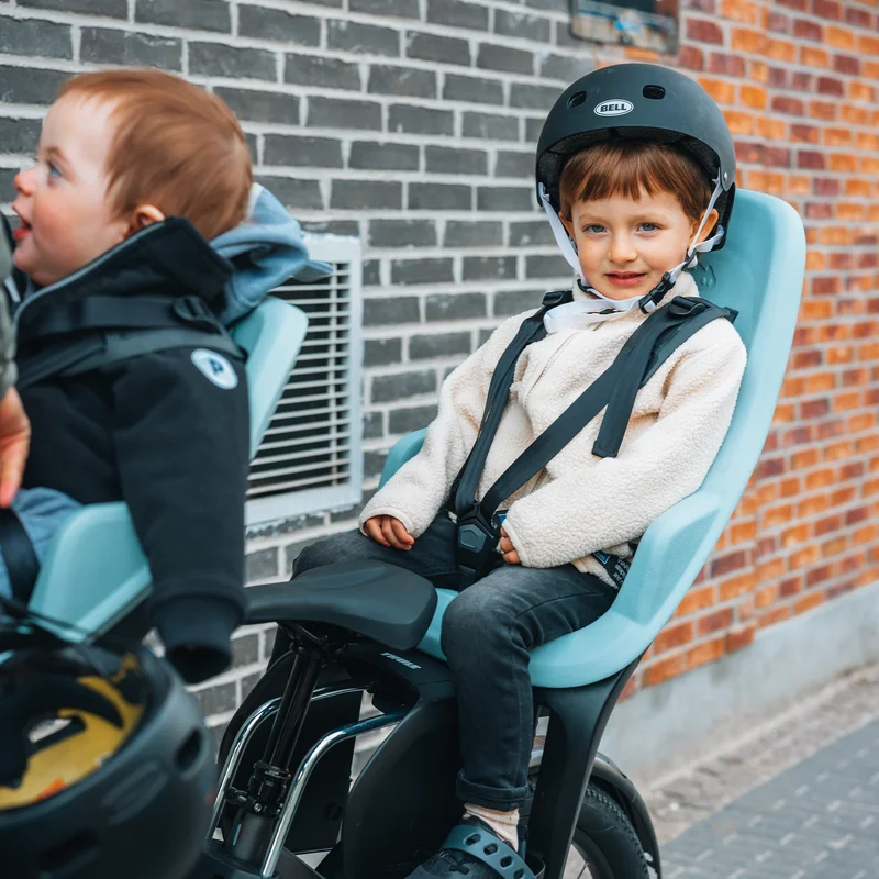Nahaufnahme eines kleinen Kindes, das die Fahrt in einem Thule Yepp 2 Sitz genießt, sicher mit einem Gurt befestigt.